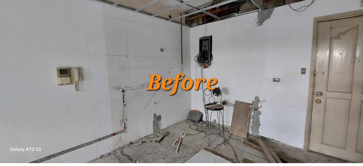 Gutted room with exposed panel before renovation